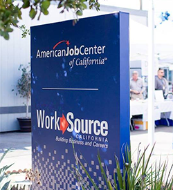 blue sign with America's Job Center of California (SM) and WorkSource California in white and red lettering (previous Hollywood WorkSource Center location sign)